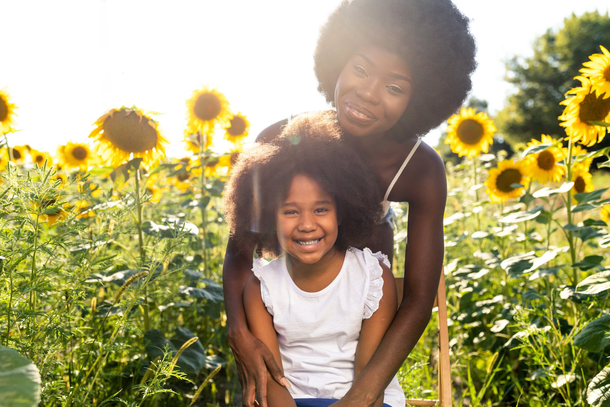 Beautiful Mom and Daughter in a Sunflowers Field